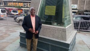 Mau Mau Governing Council National Chairman Wambugu Githaiga poses in front of Dedan Kimathi Statue
